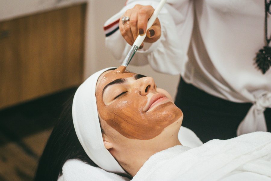 woman lying down, eyes closed, mid facial treatment for glowing skin
