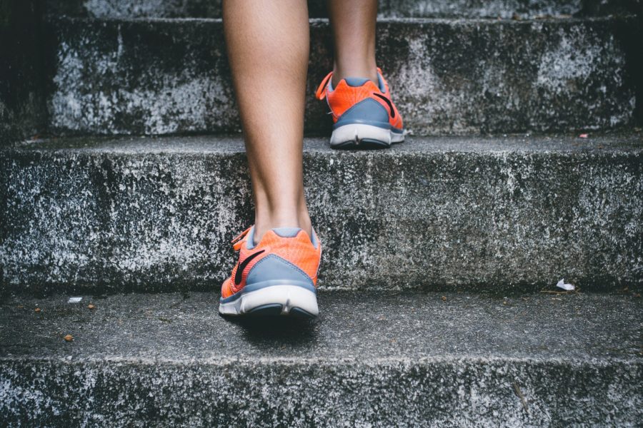 Person's feet in trainers, bare legs, ascending stairs