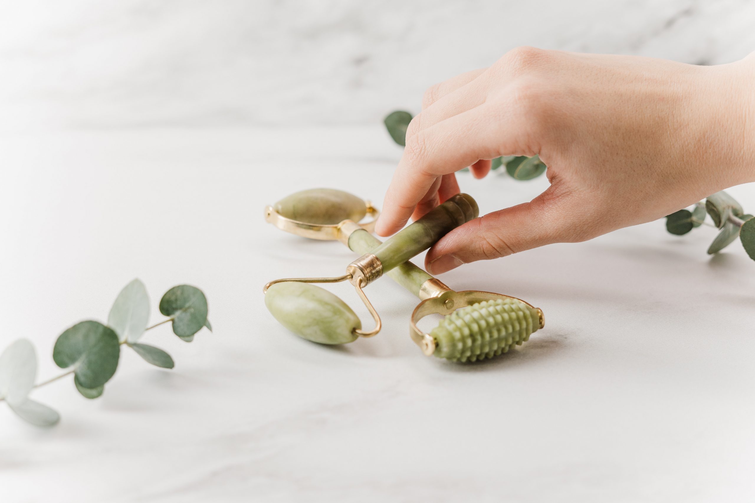 closeup of hand picking up green derma roller