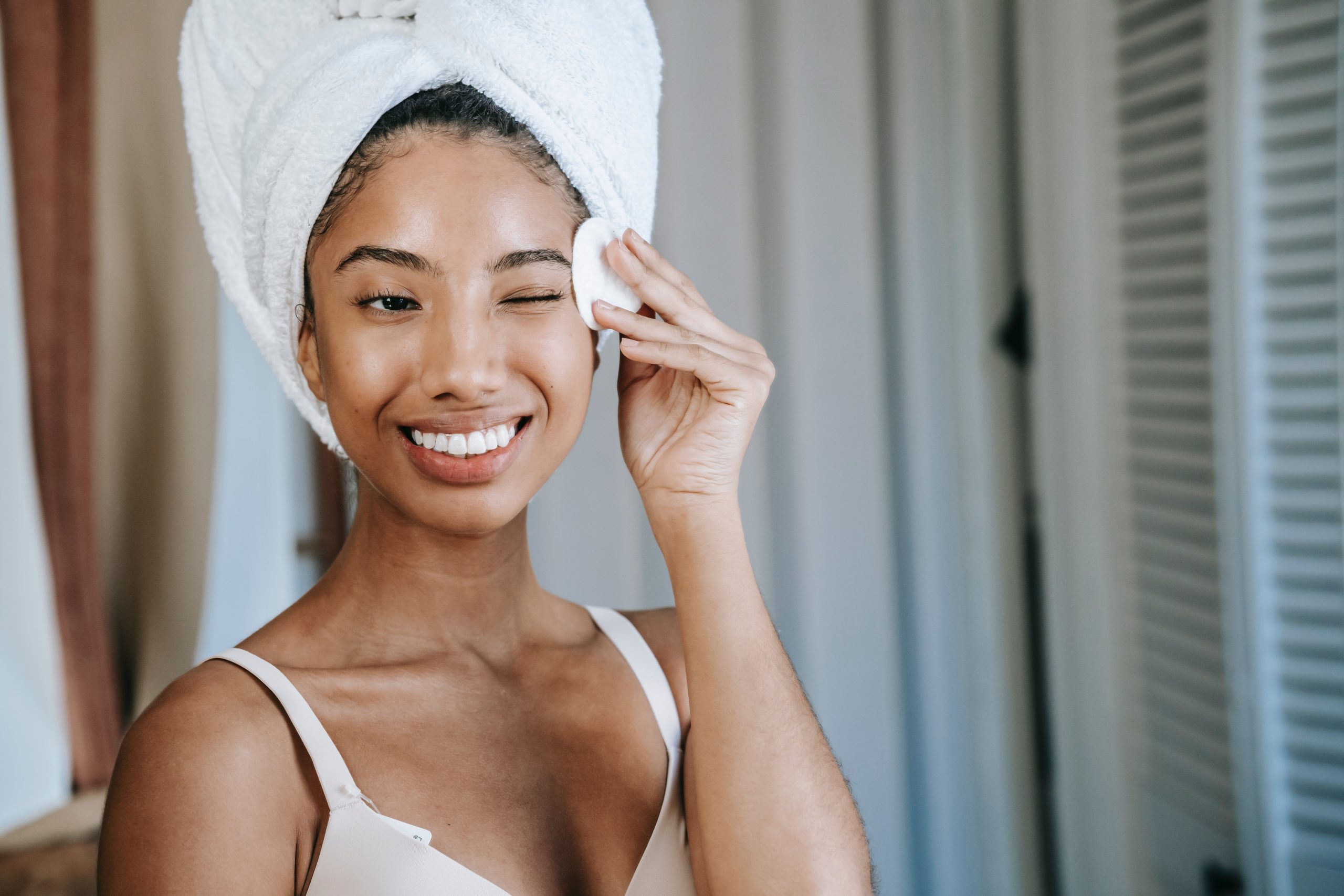 smiling woman cleansing her face