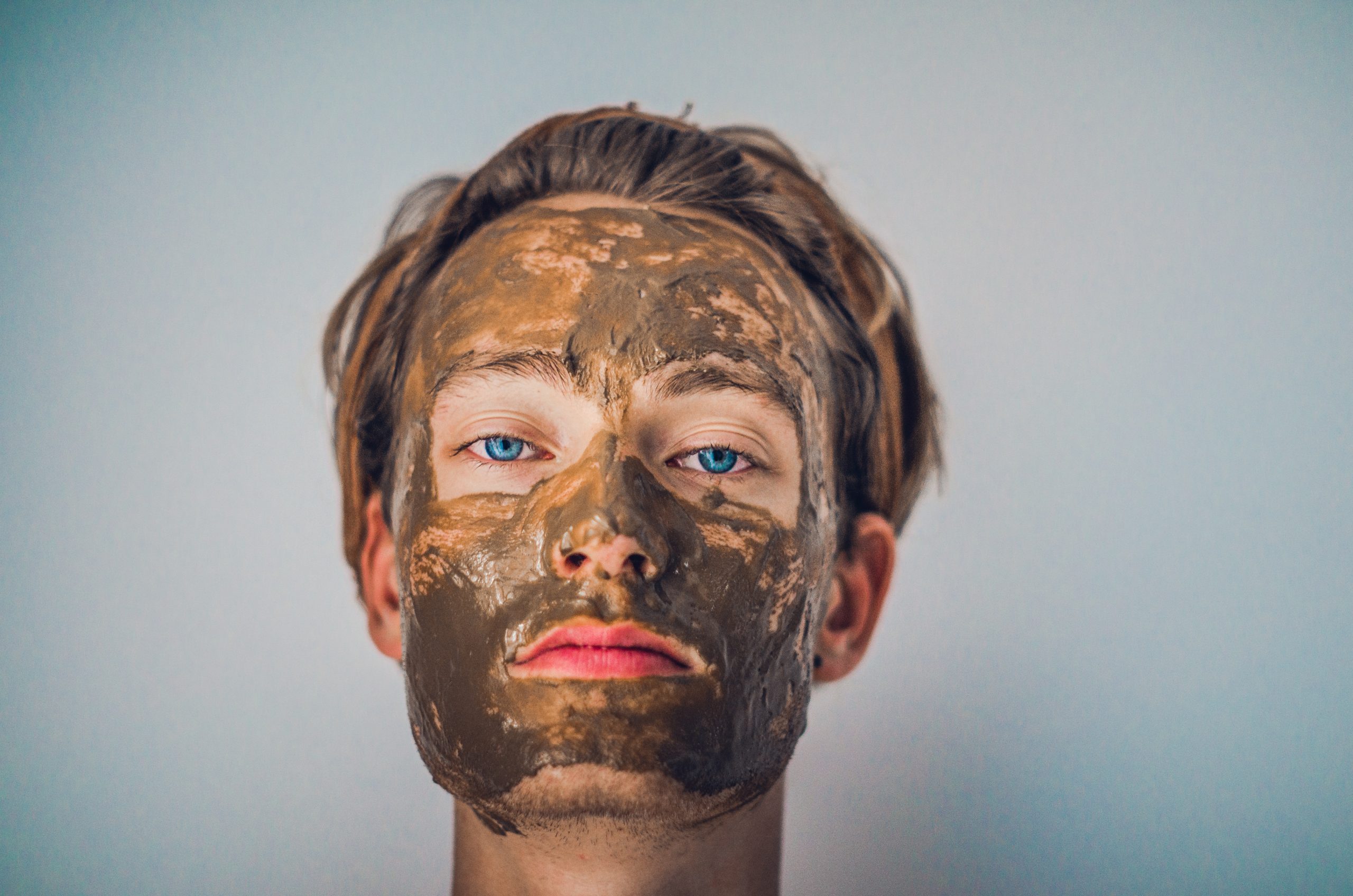 man wearing a clay mask, skincare