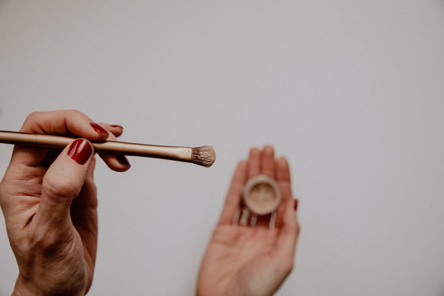 hands holding make-up pot and brush