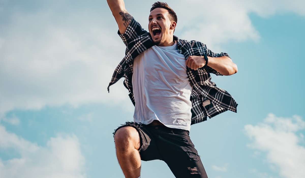 Person leaping in the air, fist to the sky, energetic look on face, how to re-energise