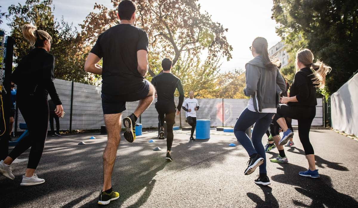 A group of people exercising outside, on the spot running