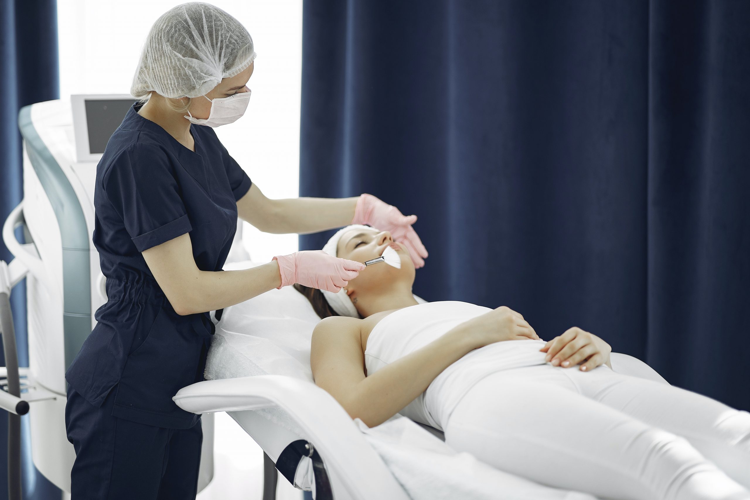 woman lying on surgical bed, mid-procedure, dermal fillers