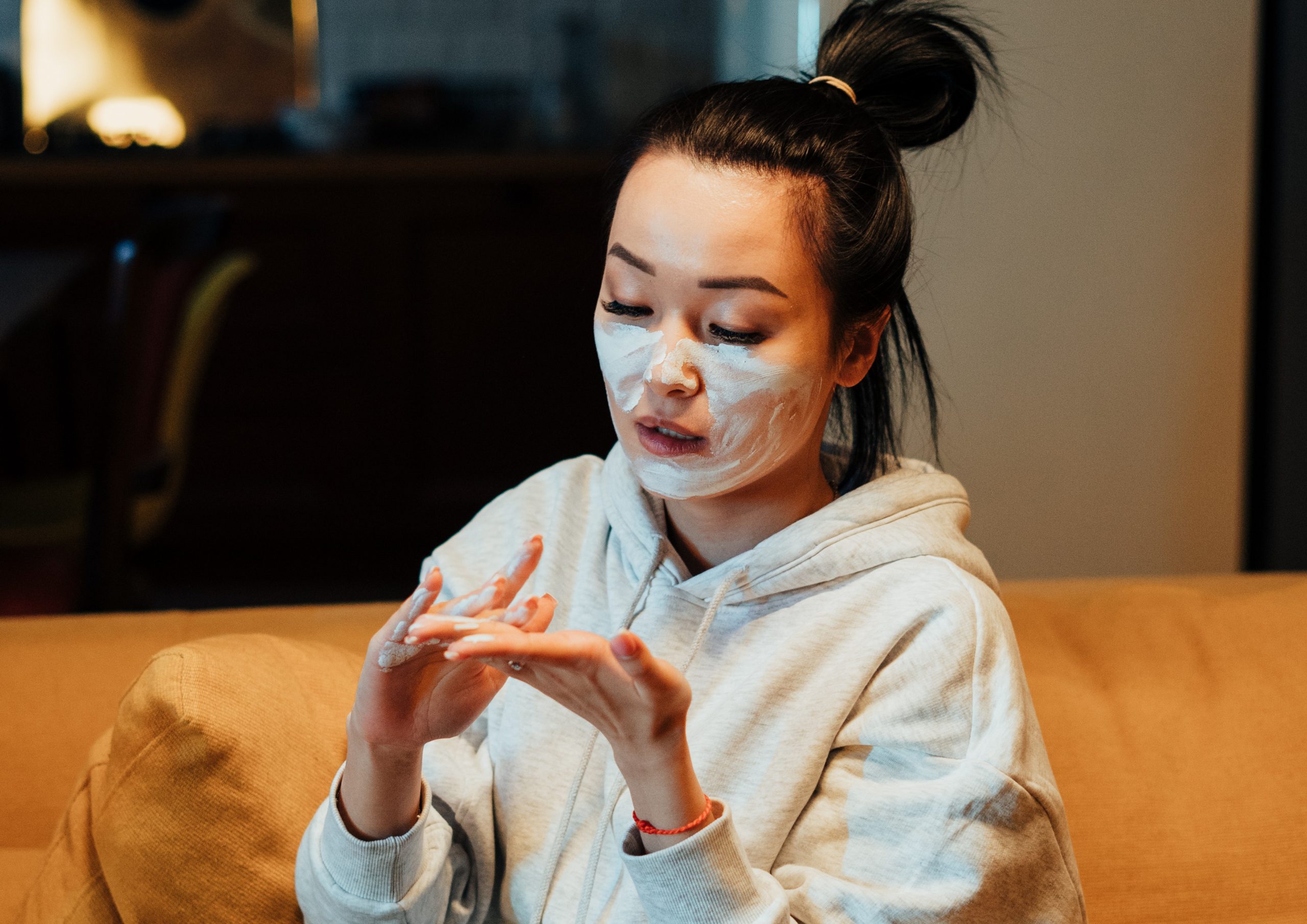 how to exfoliate, person applying cream to face