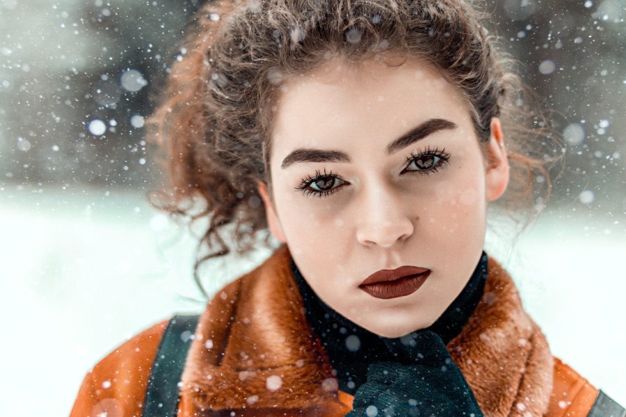 person with healthy skin looks at camera, snowy background