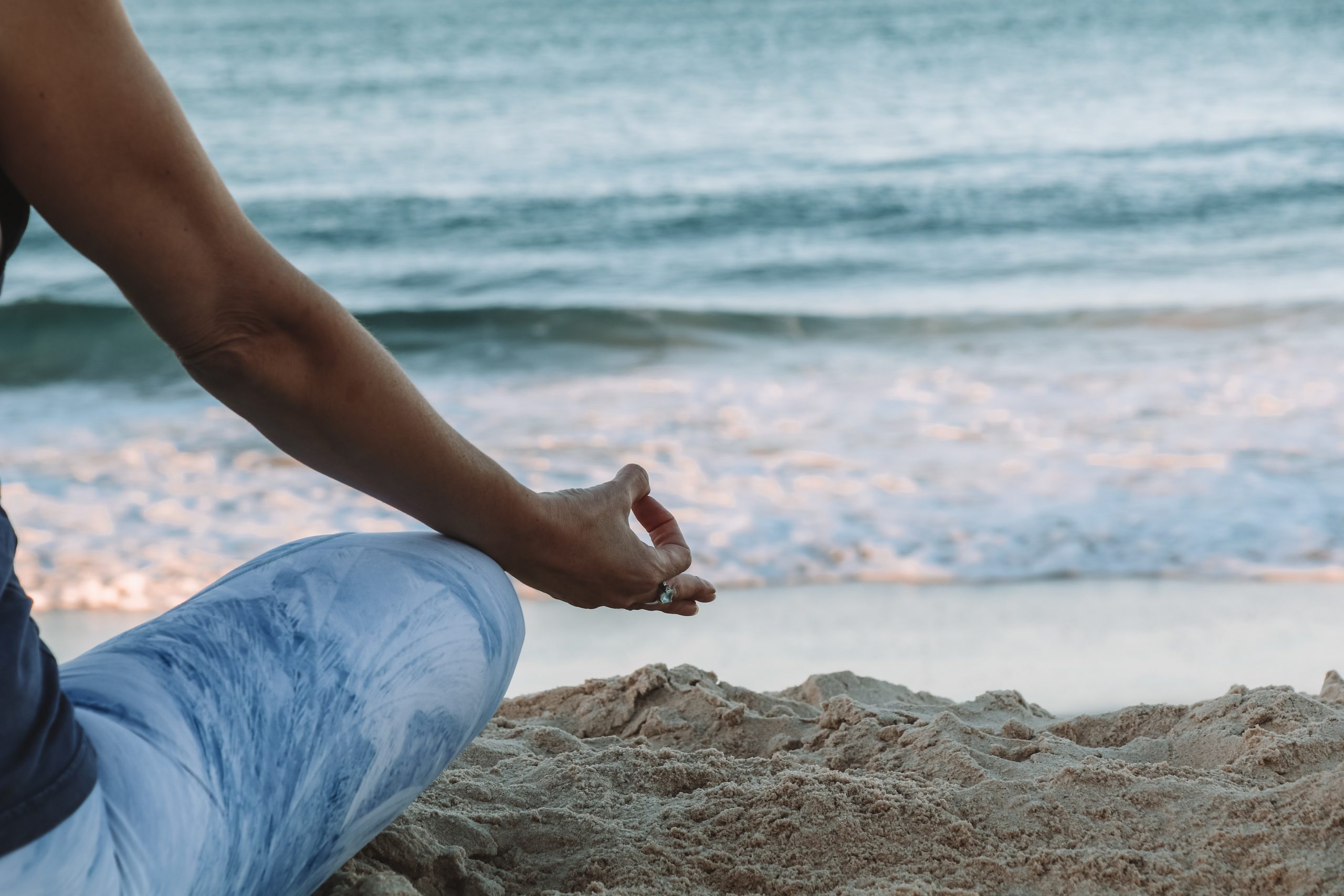 person meditating on the beach