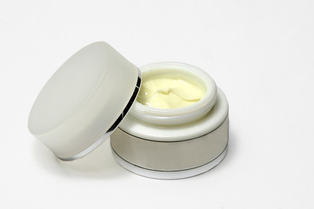 open tub of moisturiser against white background