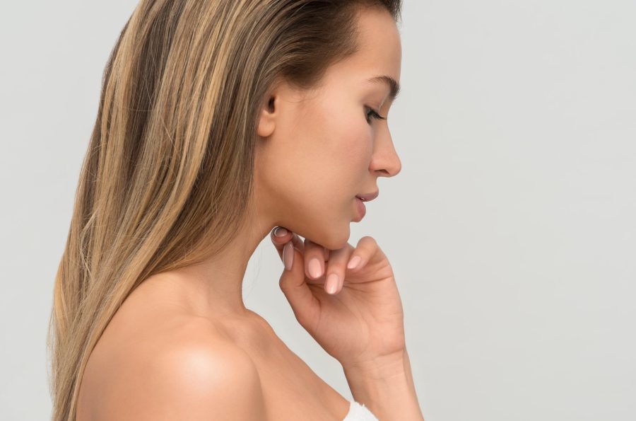 person looking thoughtful, hand on chin, ready for night time skincare routine