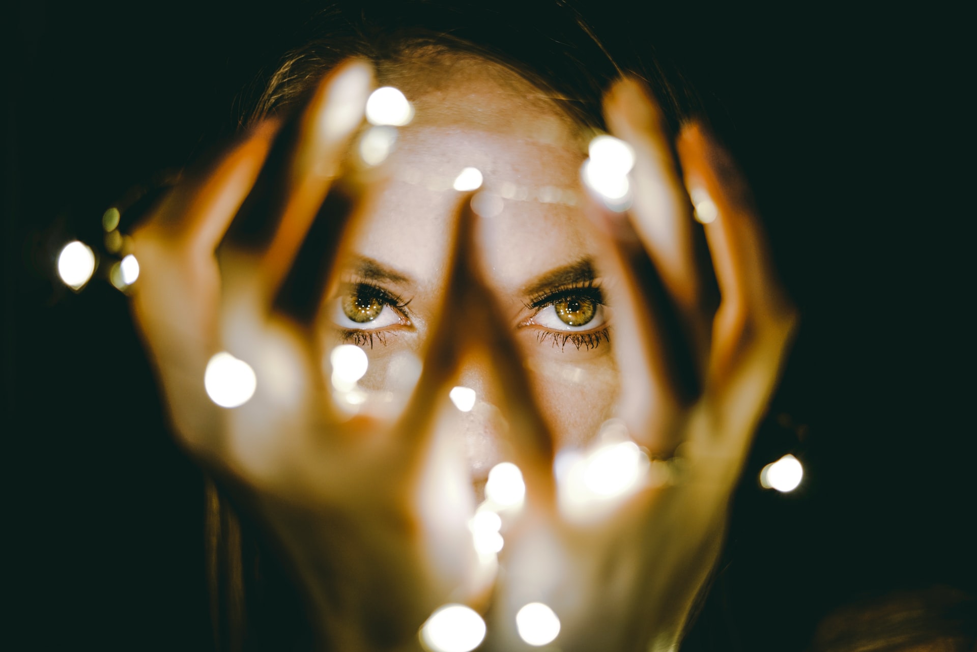 closeup of person's face and eyes behind their hands, tips for eye cream