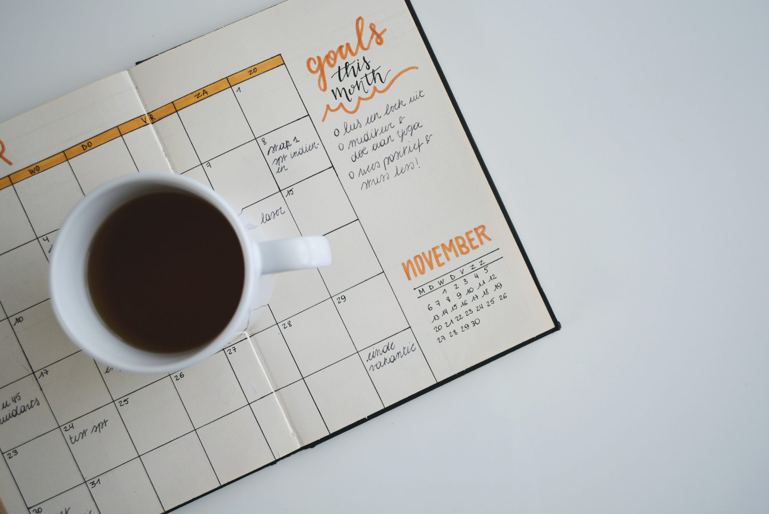 coffee cup resting on goal planner