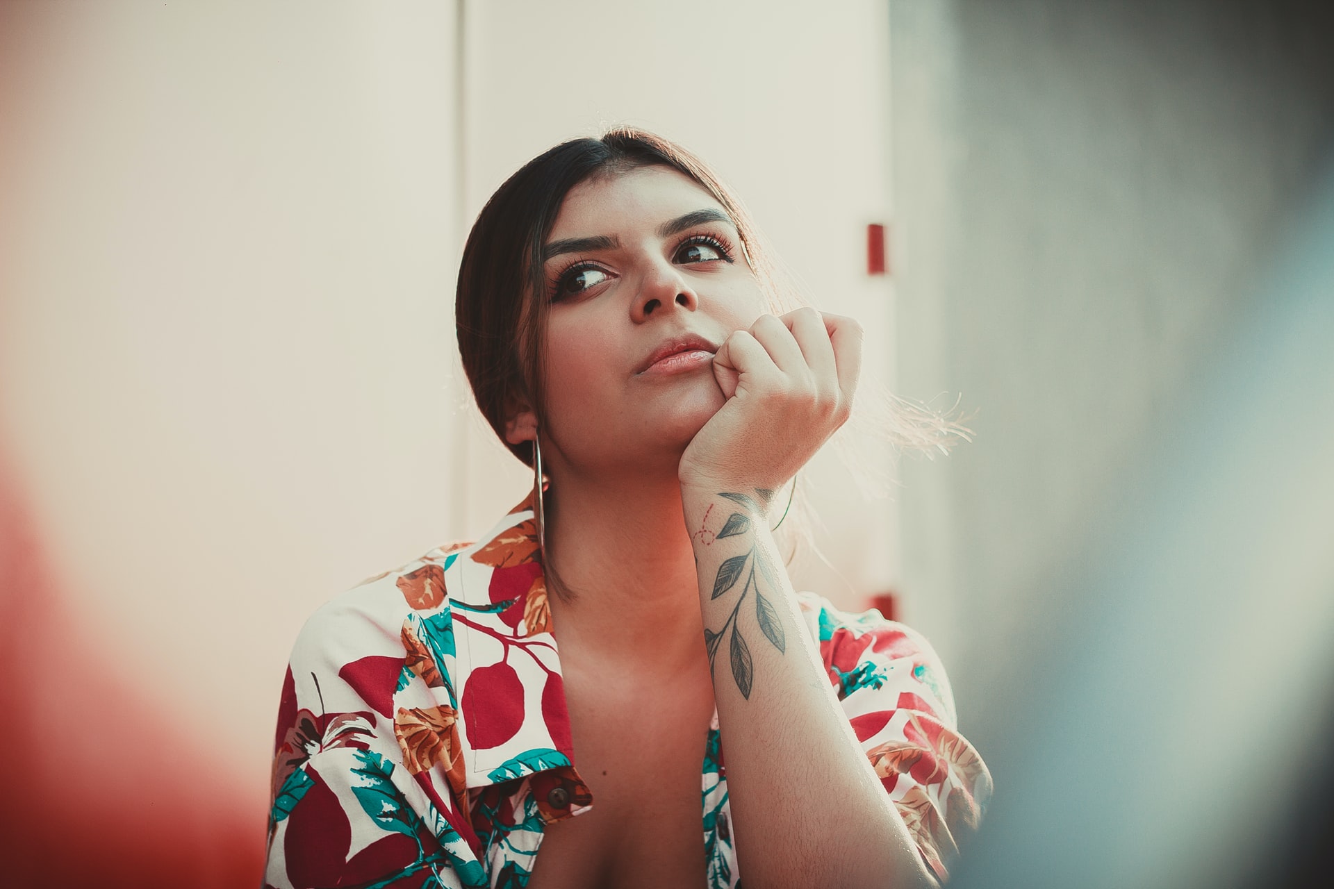 woman rests chin on her hand, looking off-camera