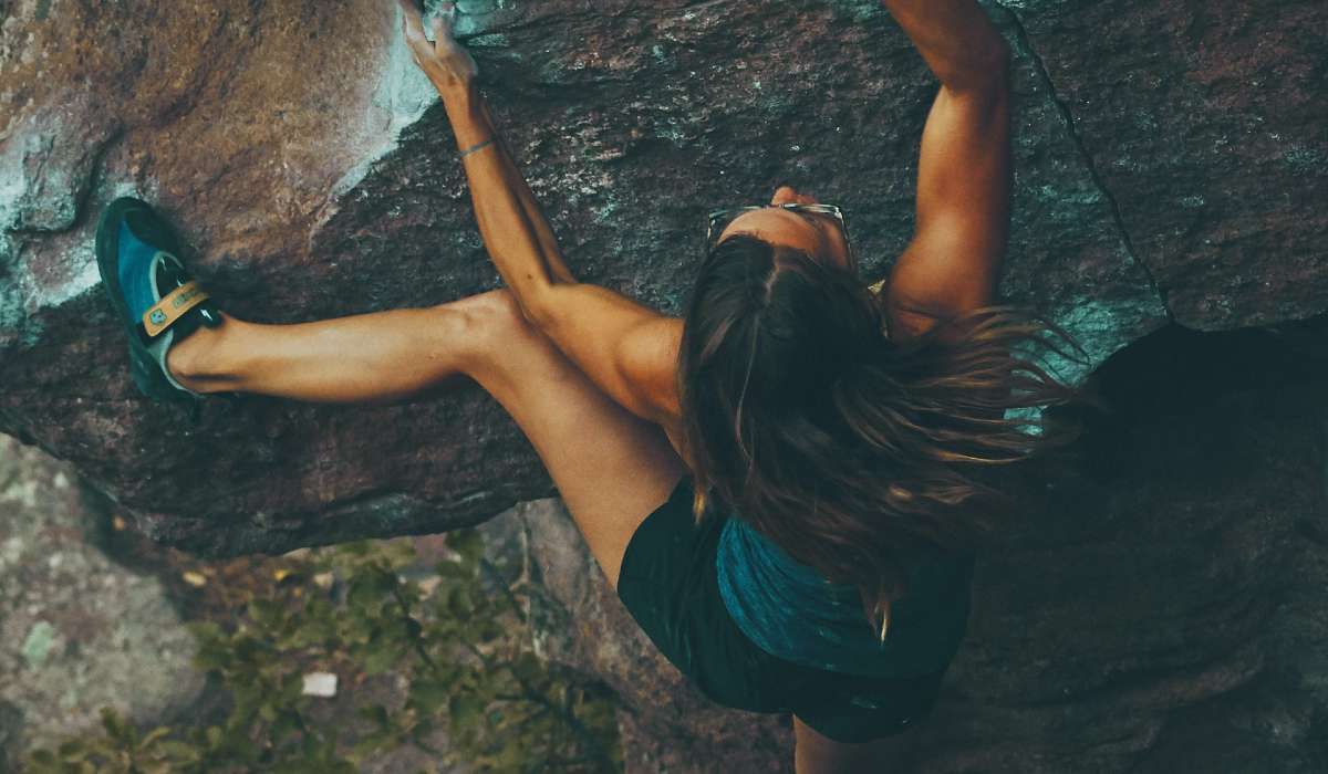 Person rock climbing to stay in shape