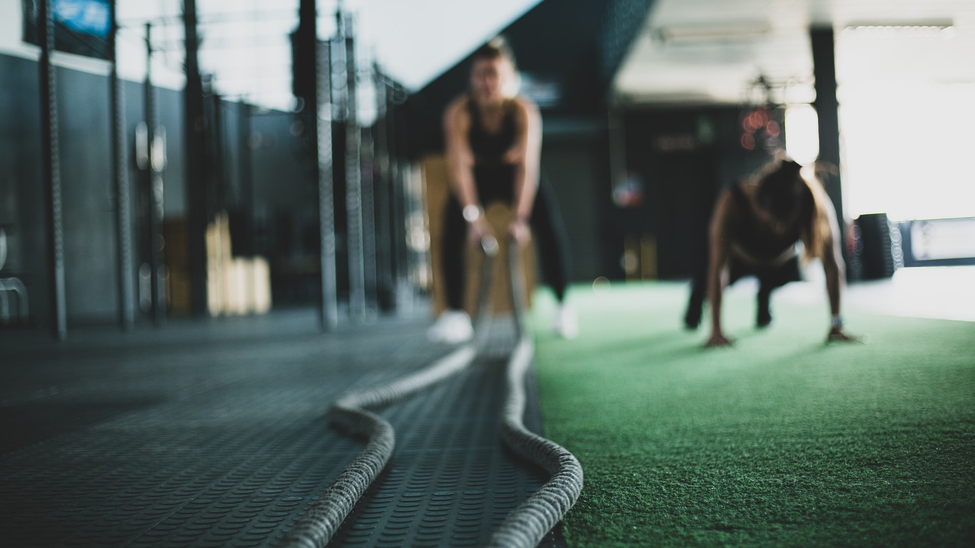 two people in background of a gym doing different exercises