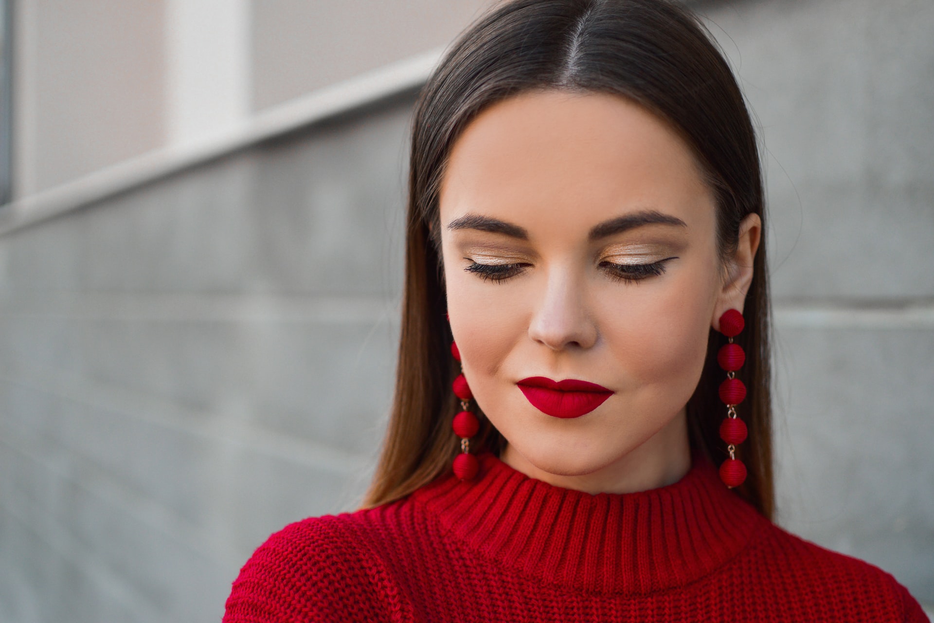 woman with full red lips looks down